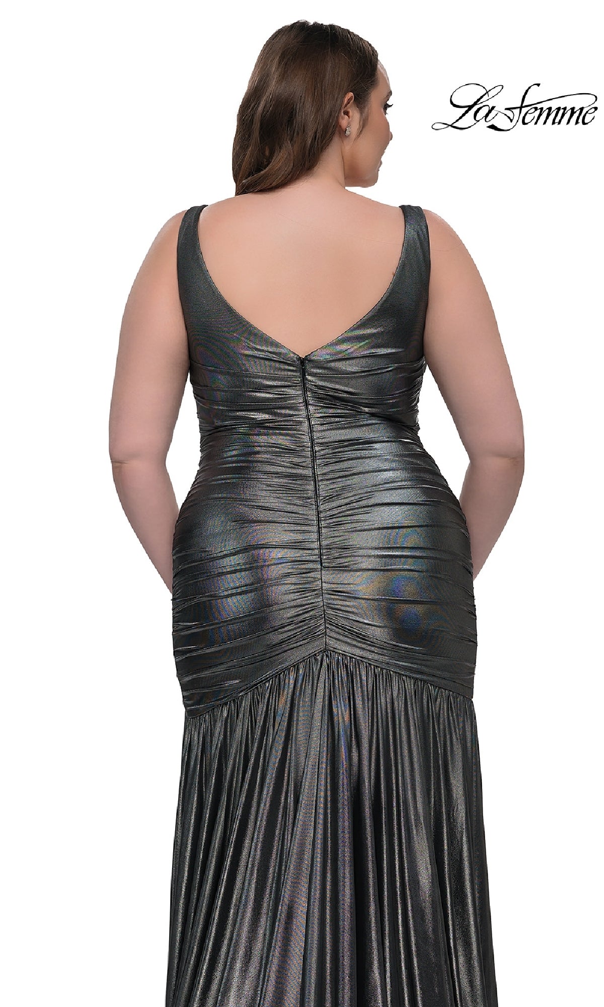 A woman is shown from the back wearing the Long Plus-Size Prom Dress: La Femme 33021, metallic and ruched with a deep V-back and flowing skirt. The